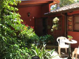 a patio with a table and chairs in front of a house at Regina Guest House in Praia do Rosa