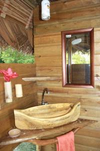 ein Holzbadezimmer mit einem Waschbecken und einem Spiegel in der Unterkunft El Toucan Loco floating lodge in Tierra Oscura