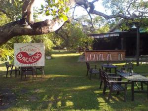 un gruppo di tavoli e sedie sotto un albero di Cashew Nut Bungalow, Ko Mook a Ko Mook