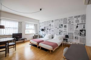 a bedroom with a bed and a wall of newspapers at The Lisbonaire Apartments in Lisbon