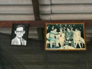 a framed picture of a man and a group of people at Cashew Nut Bungalow, Ko Mook in Koh Mook
