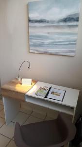a desk with a lamp and a painting on a wall at Latitude Adjustment in San Juan