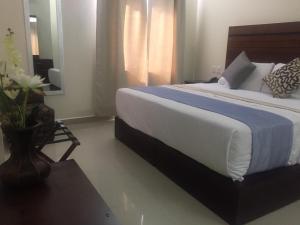 1 dormitorio con 1 cama grande con manta azul y blanca en Gran Plaza Hotel Centro Histórico, en Iguala de la Independencia