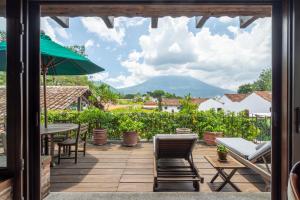 a patio with a table and chairs and a mountain at Hotel Museo Spa Casa Santo Domingo in Antigua Guatemala
