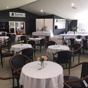 CoonambleTerminus Hotel的用餐室配有白色的桌椅和鲜花