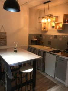 uma cozinha com uma mesa e dois bancos em APPARTEMENT AVEC GARAGE CENTRE HISTORIQUE DE BÉZIERS em Béziers