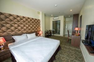 a bedroom with a large bed and a flat screen tv at 3MG Lakeside Hotel in Hai Phong
