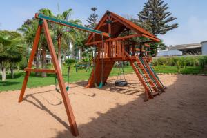 a playground with a wooden play structure in a park at Odyssee Park Hotel in Agadir