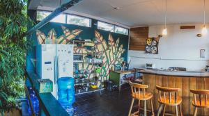 Zimmer mit einer Bar mit Stühlen und einem Kühlschrank in der Unterkunft Bella's Backpackers Cayo in San Ignacio