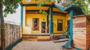 uma casa amarela com uma cerca em frente em Bella's Backpackers Cayo em San Ignacio
