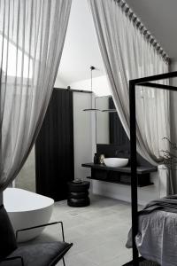 a black and white bathroom with a tub and a sink at The Bower Byron Bay in Byron Bay