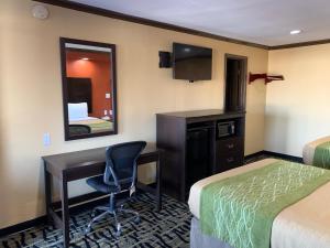 a hotel room with two beds and a desk and a mirror at Journey Inn Marion in Marion