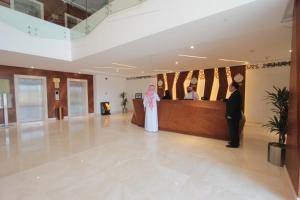 a bride and groom standing in a lobby at Taj Jeddah Hotel Apartment in Jeddah