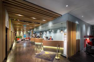 a lobby of an office with a woman sitting at a desk at ibis Melbourne Hotel and Apartments in Melbourne