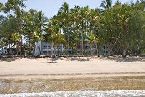 a beach with palm trees and palm trees at Agincourt Beachfront Apartments in Clifton Beach