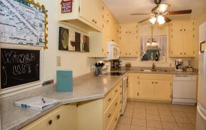 a kitchen with yellow cabinets and a chalkboard on the wall at Wine’D Up in Fredericksburg
