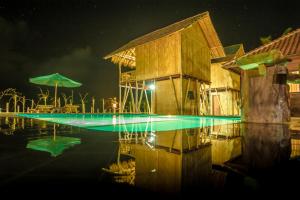 a swimming pool at night with a building at Pondok Bamboo Villa in Nusa Penida