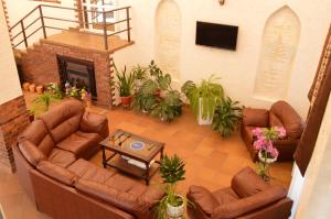 a living room with leather furniture and a fireplace at Hotel Avallon in Adler