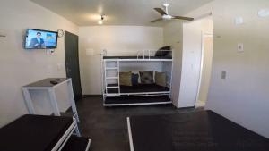 Habitación pequeña con cama y ventilador de techo. en Praia do Forte Wifi, en Cabo Frío