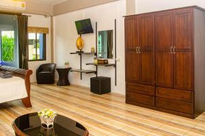 a living room with a large wooden cabinet at Allstar Guesthouse in Karon Beach