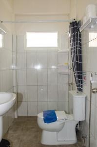 a white bathroom with a toilet and a sink at Allstar Guesthouse in Karon Beach