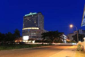 um edifício alto com um cartaz à noite em Borneo Royale Hotel em Tawau