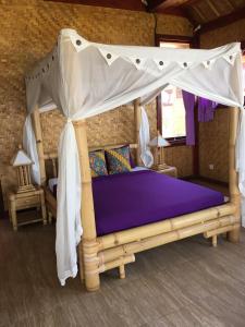 a bedroom with a bed with a canopy at Good Karma Bungalows in Amed