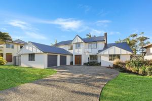 a large white house with a driveway at CANAL HOME NEAR MOOLOOLABA - Kooringal in Buddina