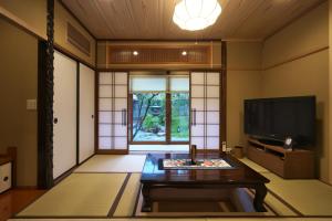 a living room with a tv and a coffee table at Musashi Sakaean in Kanazawa