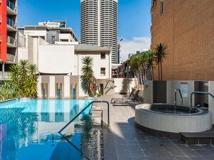 a swimming pool with a hot tub in a city at Code Apartment in Perth