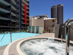 a large swimming pool in front of a building at Code Apartment in Perth