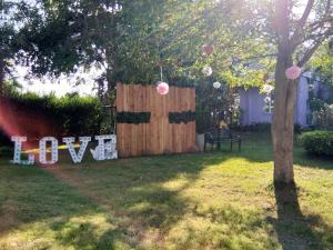 a fence in a yard with a sign that says love at Ban Bang Home Resort in Haad Chao Samran