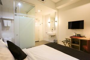 a bedroom with a bed and a bathroom with a sink at Avenue J Hotel, Central Market in Kuala Lumpur