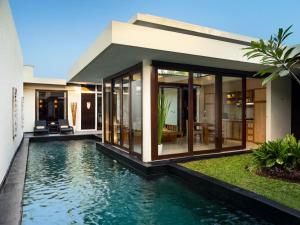 a house with a swimming pool in front of it at Avani Seminyak Bali Resort in Seminyak