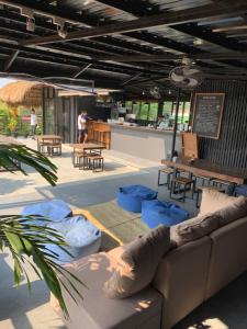 ein Wohnzimmer mit Sofa, Stühlen und Tischen in der Unterkunft Dayon Hostel in Coron