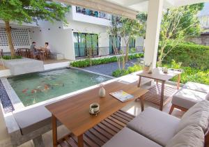 uma sala de estar com uma mesa e uma piscina em Mini House Aonang Hotel SHA Plus em Praia de Aonang