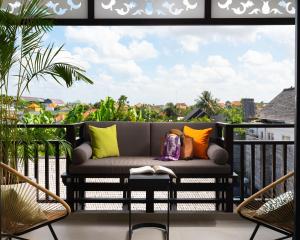 Avani Seminyak Bali Resort في سمينياك: أريكة على شرفة مطلة