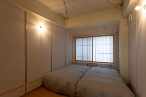 Cama grande en habitación con ventana en 2254, en Kioto