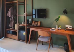 a room with a desk with a chair and a television at Mini House Aonang Hotel SHA Plus in Ao Nang Beach