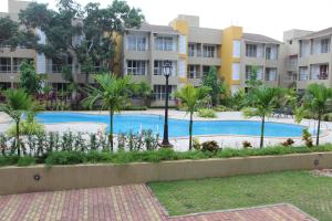 una piscina con palmeras y edificios en Most convenient 2 BR apartment in central Anjuna, en Anjuna