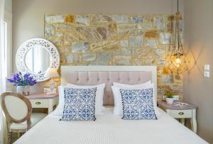 a bedroom with a bed with blue and white pillows at anastasia studios in Skala Potamias
