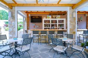 a patio with tables and chairs and a bar at anastasia studios in Skala Potamias