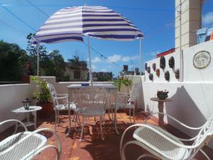 a table and chairs under an umbrella on a patio at Casa Blanca 917 in Havana