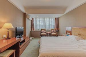 a hotel room with a large bed and a television at Huangshan Tiandu International Hotel in Huangshan