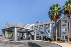 a hotel with palm trees in front of a building at Quality Inn Downtown - near Market Square in San Antonio