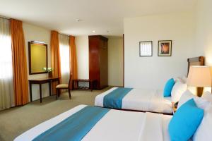 Habitación de hotel con 2 camas y escritorio en Citi Park Hotel, en Cebú