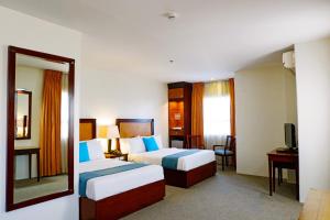 a hotel room with two beds and a mirror at Citi Park Hotel Cebu powered by Cocotel in Cebu City +71 photos