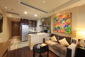 ein Wohnzimmer mit einem Sofa und einer Küche in der Unterkunft Lee Garden Service Apartment in Peking