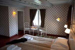 1 dormitorio con 1 cama, 1 mesa y 1 silla en Mustion Linna / Svartå Manor, en Svartå