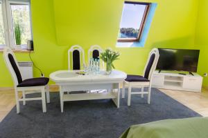salon ze stołem, krzesłami i telewizorem w obiekcie Agroturystyka Krężniczanka w mieście Lublin